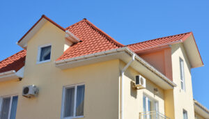 A home with a tile roof and white gutters, soffit, and fascia